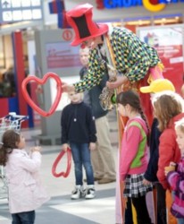 Stelzenclown Peppino schenkt den Kindern seine bunten Modellierballons
